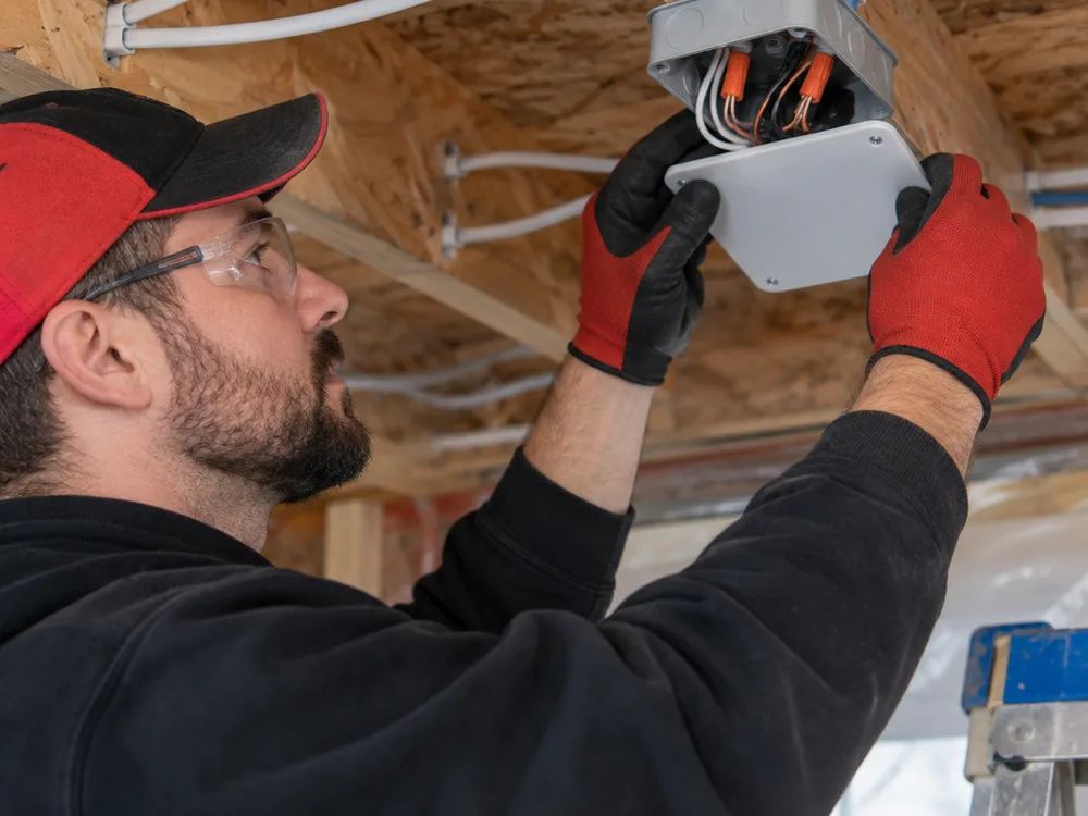 Electrician wiring a junction box in new construction framing
